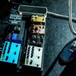 person standing beside assorted-color guitar tuner lot