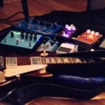 a guitar sitting on top of a hard case